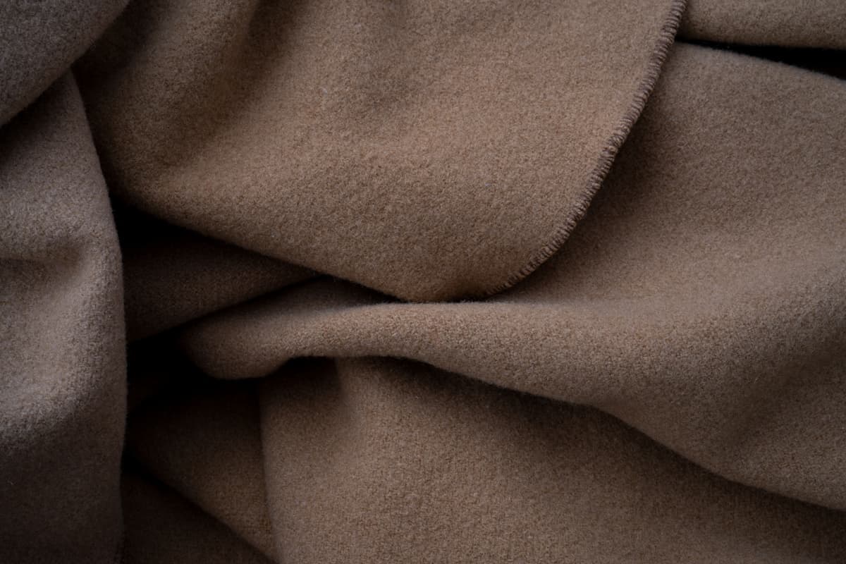 Folded neutral wool blanket showing its texture