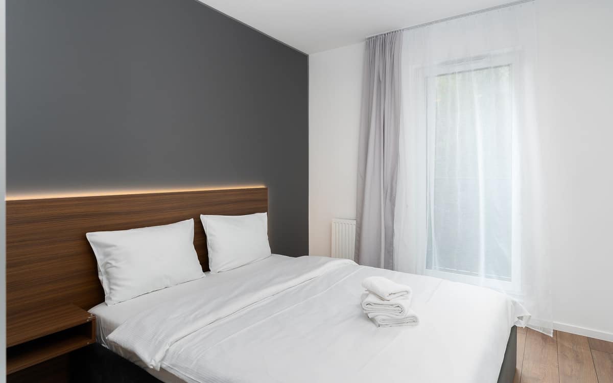 A white comforter spread across a made bed