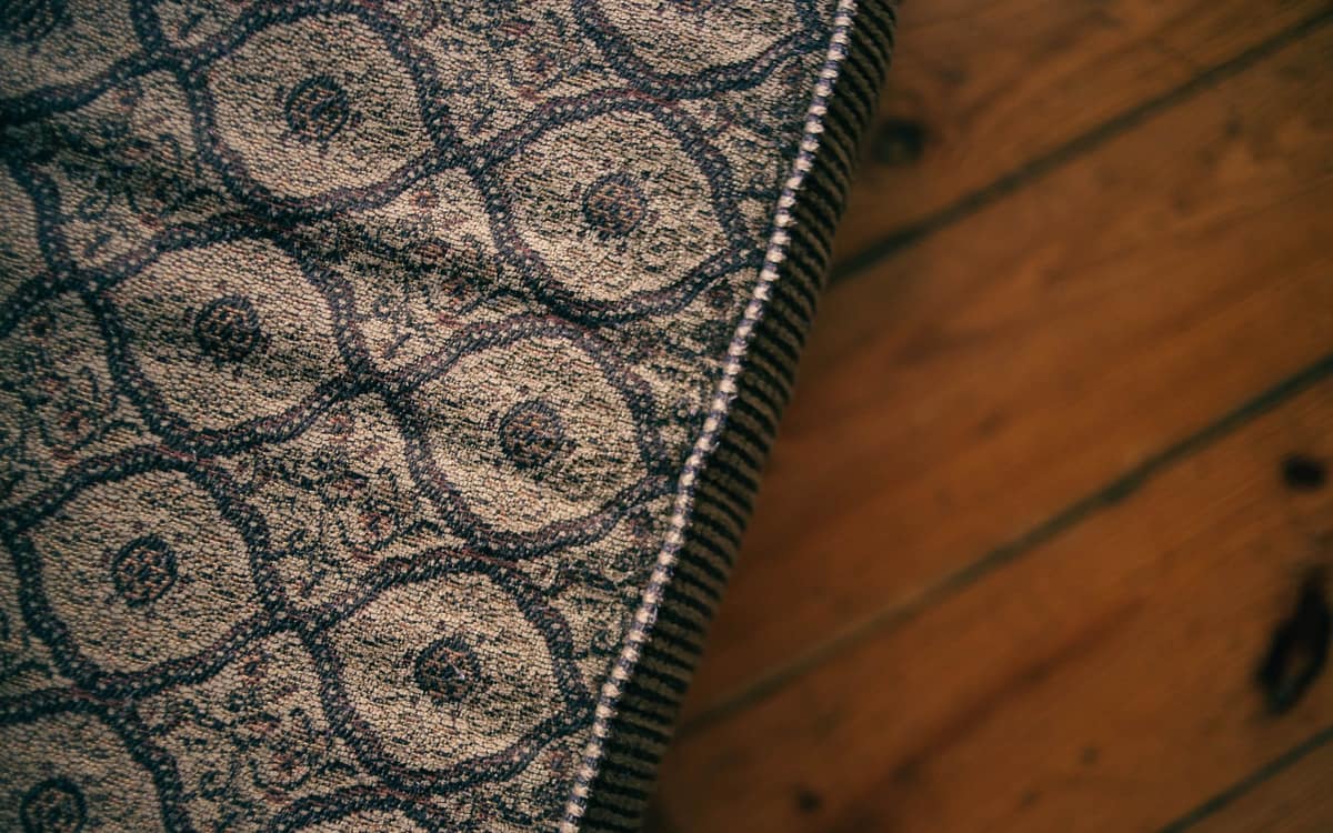Close-up of a patterned mattress corner on a wooden floor