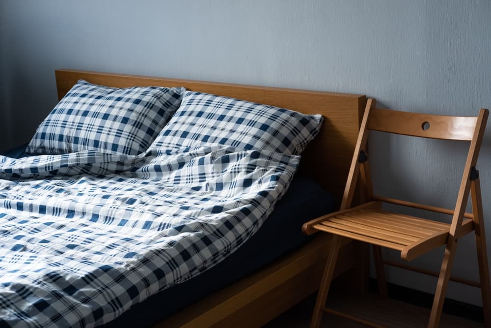 A mattress with a folded topper resting on it