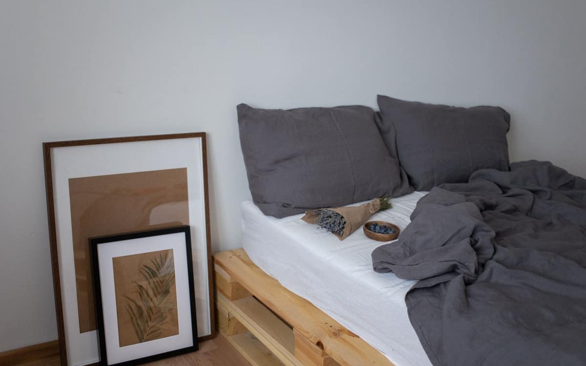 Dark grey bedding and black pillows on a neatly made bed
