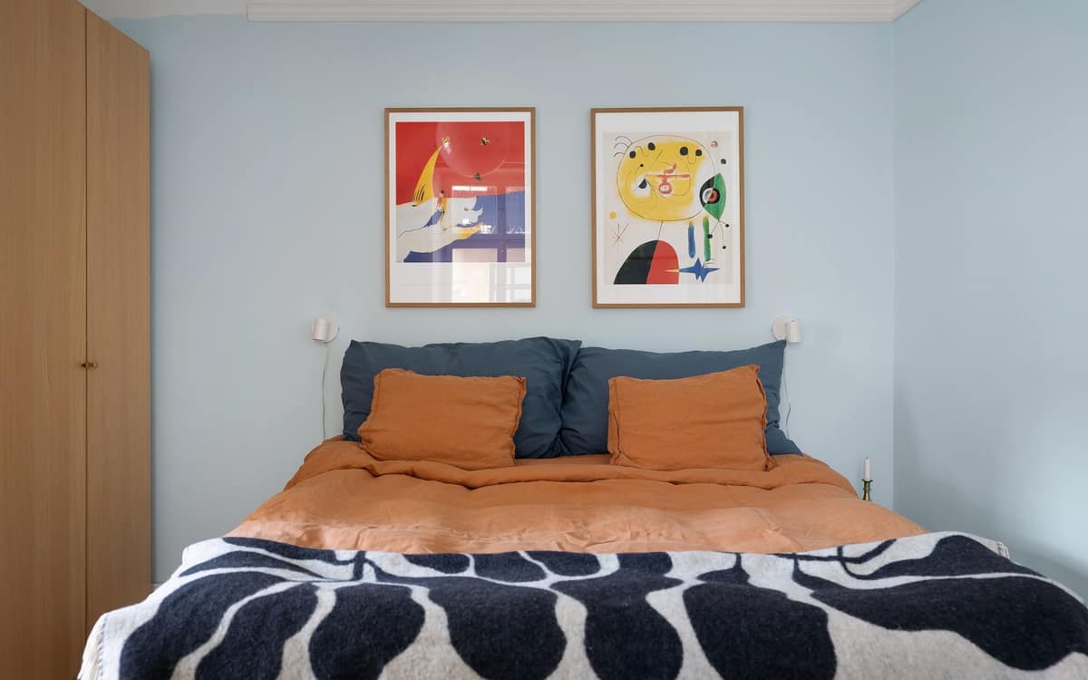 A neatly made bed dressed with two separate duvets