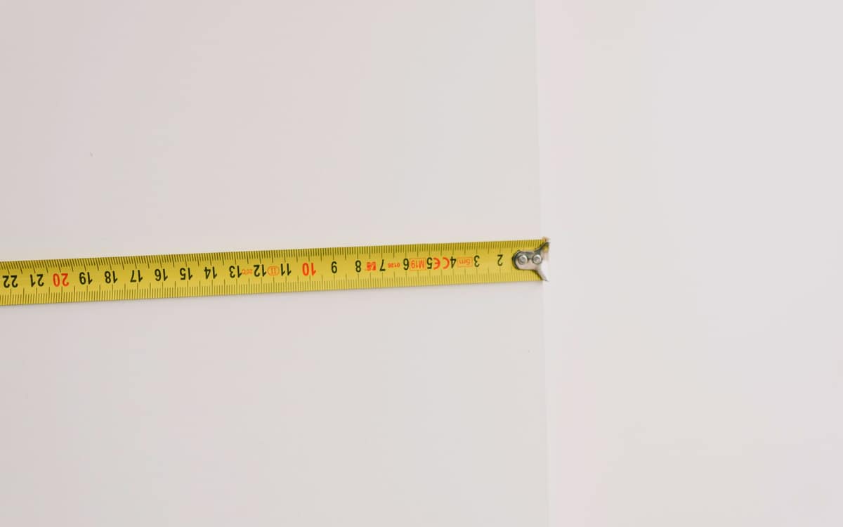 A tape measure extended across a plain white surface