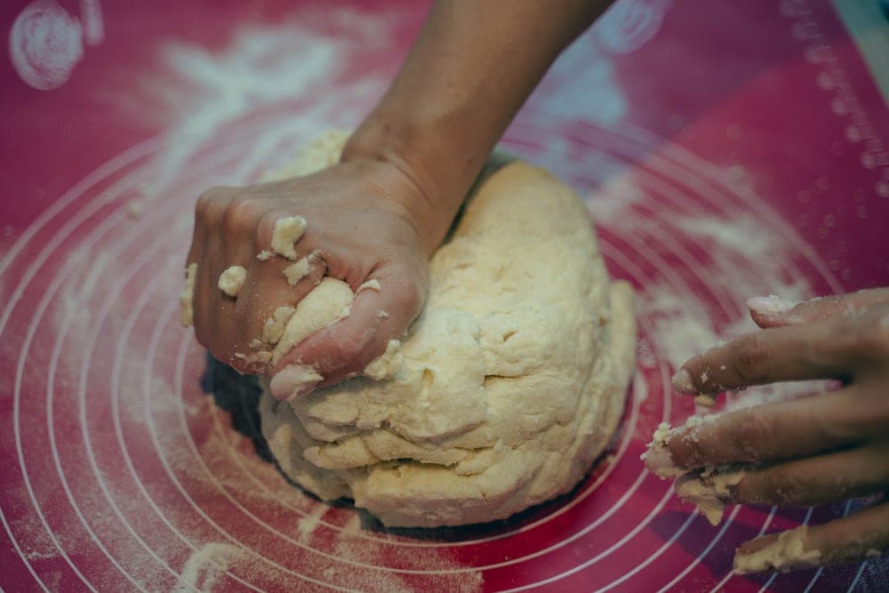 A hand pressing into a mattress surface