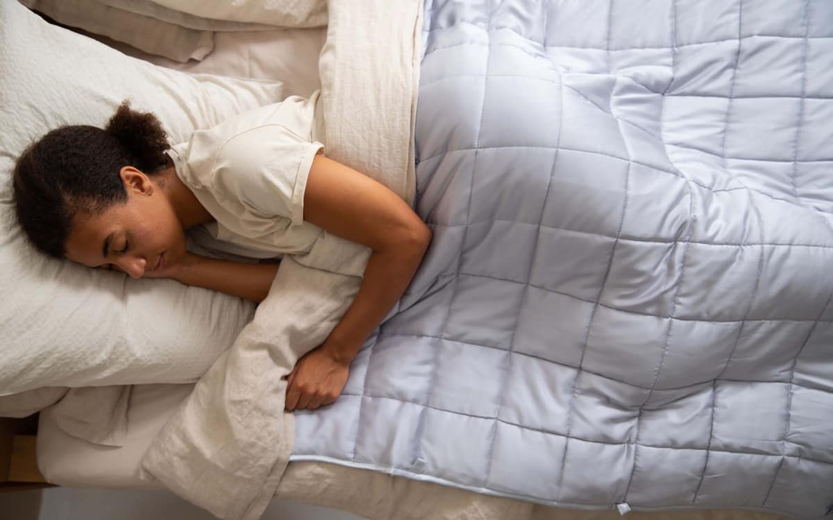 A weighted blanket folded on a bed