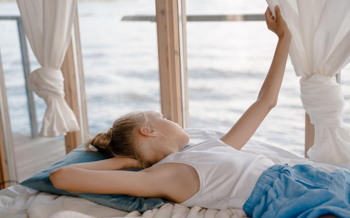 An open bedroom window with a light curtain in the breeze